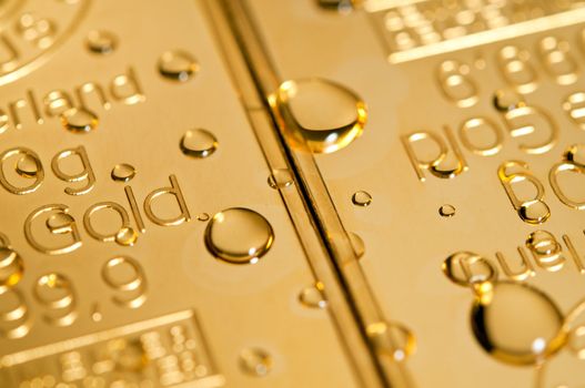 gold ingot and water drops background. closeup.