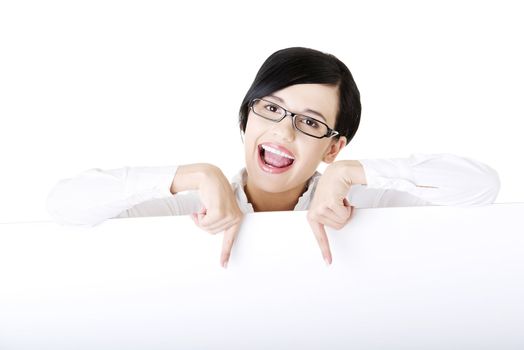 Smiling young business woman showing blank signboard, over white background isolated