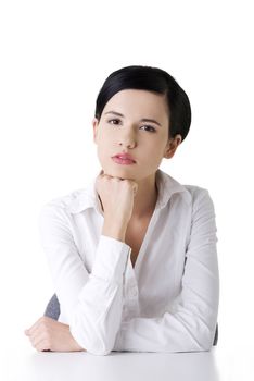 Pretty young woman in sitting at the desk, isolated on white