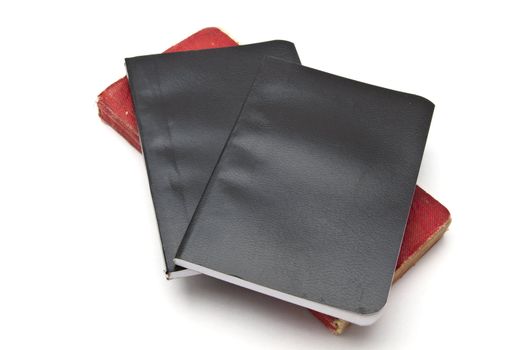 Red and black notebooks closeup on white 