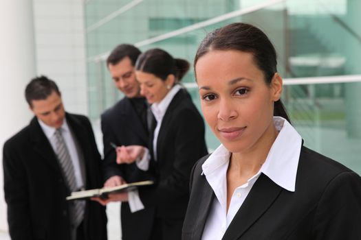 Woman standing with colleagues in front of an office building