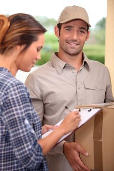 Woman signing for a courier delivered parcel