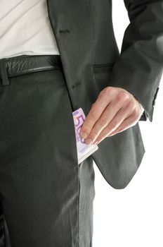 Front view of a businessman putting large amount of money in his pants pocket.