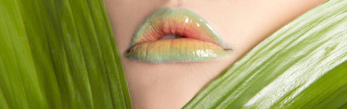 Woman's lips with green leafs