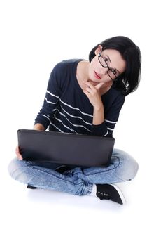 A young thoughtful woman with a laptop sitting isolated on white background