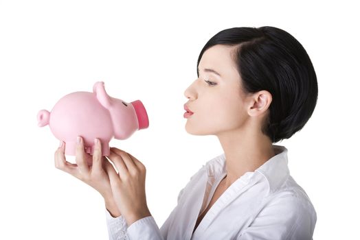 Happy business woman with her savings in piggy bank