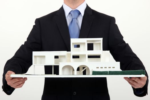 Architect holding scale replica of building