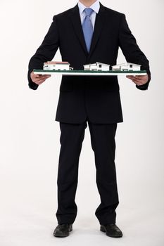 Businessman holding a model of a housing estate