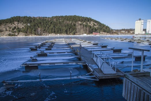 Floating docks are frozen in the ice at the harbor of Halden, Norway. The picture was shot one day in March 2013.