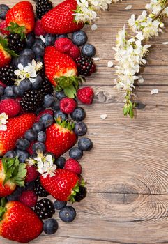 Berries and white flower on Wooden Background