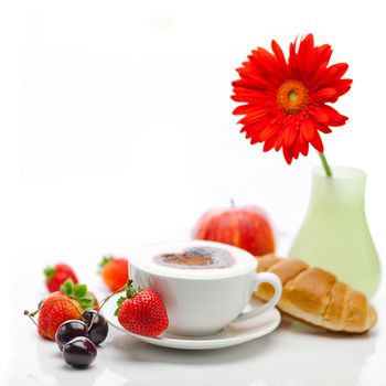cappuccino in a cup in the shape of hearts,gerbera,apple,cherry,croissant and strawberries isolated on white