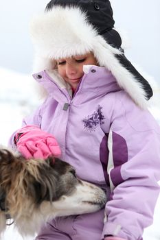 Little girl with a dog in the snow
