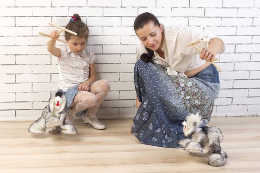 Mother and 5 year old daughter playing with a toy dog
