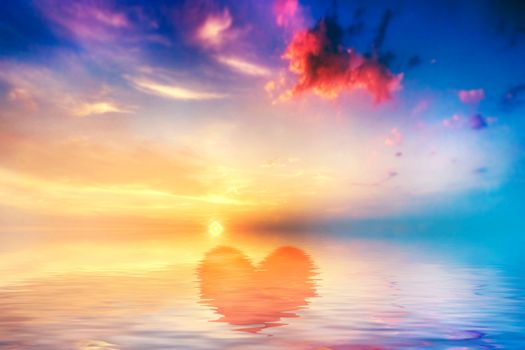 Hearth shape in calm ocean at sunset. Beautiful sky, clouds and colors