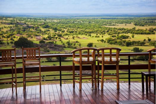 Savanna landscape in Serengeti, Tanzania, Africa. Chairs on the terrace for observation