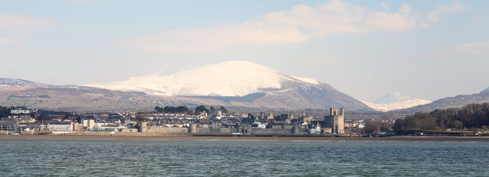 Medievil Caernarfon castle and town with Snowdonia as a back drop in north Wales 