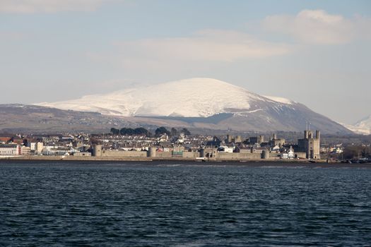 Medievil Caernarfon castle and town with Snowdonia as a back drop in north Wales 