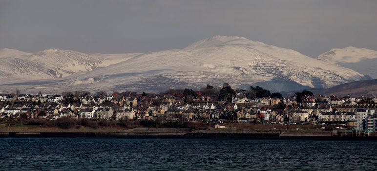 Medievil Caernarfon castle and town with Snowdonia as a back drop in north Wales 