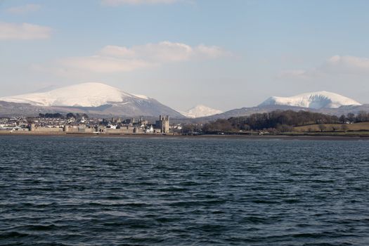 Medievil Caernarfon castle and town with Snowdonia as a back drop in north Wales 