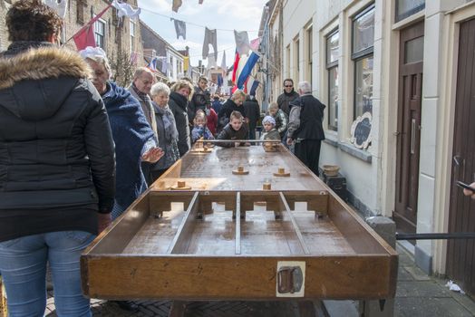 Brielle, Holland - April 1, 2013: children playing dutch shuffleboard on the annual market celebrating the uprising of Low Countries against Spain in the 80 Years' War