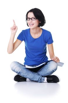 Studying happy young woman reading her notebook for school and pointing on copy space.