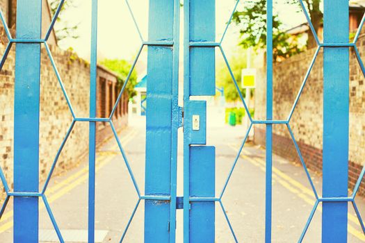 Close up of a locked blue metal school gate