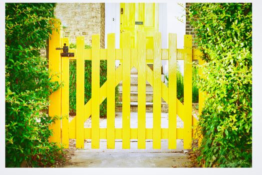 A nice yellow garden gate in front of an english house
