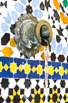 A tap in a Moroccan zellij tile wall