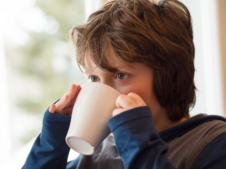 Young boy drinking a hot chocolate