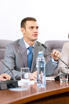 Portrait of a businessman, said into the microphone, the meeting