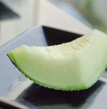 single cantaloupe melon slices  on dish .