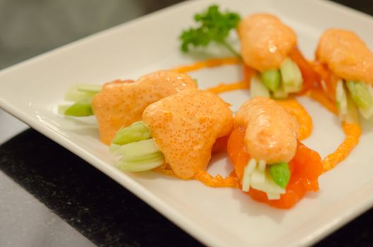 close up  salmon rolls with vegetable on  dish .