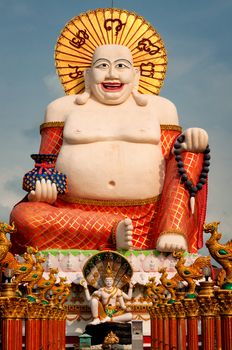 Fat laughing Buddha over blue sky, Koh Samui. Thailand