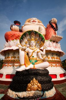 Fat laughing Buddha over blue sky