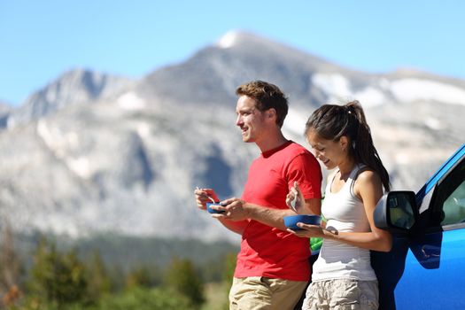 Couple on car road trip travel eating lunch break outdoors smiling happy. Multiracial couple, Asian woman, Caucasian man People in Yosemite National Park, California, United States.