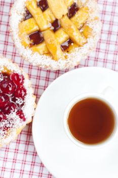 beautiful cake with berries and tea on plaid fabric