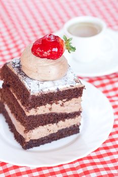 beautiful cake with strawberry and tea on plaid fabric