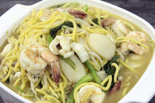 Hokkien Mee Stir Fry Yellow Noodles with Prawns Squids Fishcake and Green Vegetables Top View Closeup