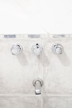 faucet in the bathroom on the background tile