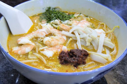 Singapore Curry Laska with Prawns Fishcake and Sambal Chili Paste Garnished with Daun Kesom Leaves Macro