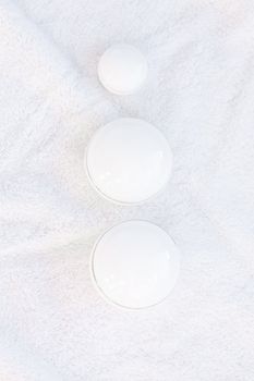 cosmetic containers lying on white towel