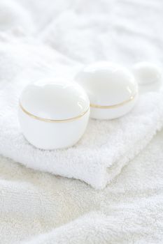 cosmetic containers lying on white towel