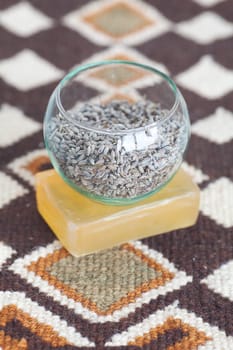 lavender in bowl and soap on ethnic mat