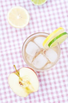 water with lemon and lime,apple in a glass with ice