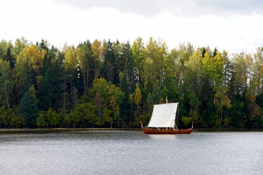 Sailing boat on a background of a forest 