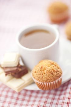 bar of chocolate,tea and muffin on plaid fabric