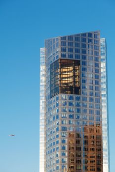 Beautiful modern office building and airplane against the blue sky