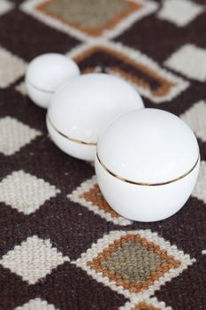 cosmetic containers lying on ethnic mat