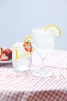 cocktail with ice,lemon and strawberries on a plate