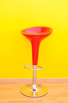 bar chair against a yellow wall in the apartment